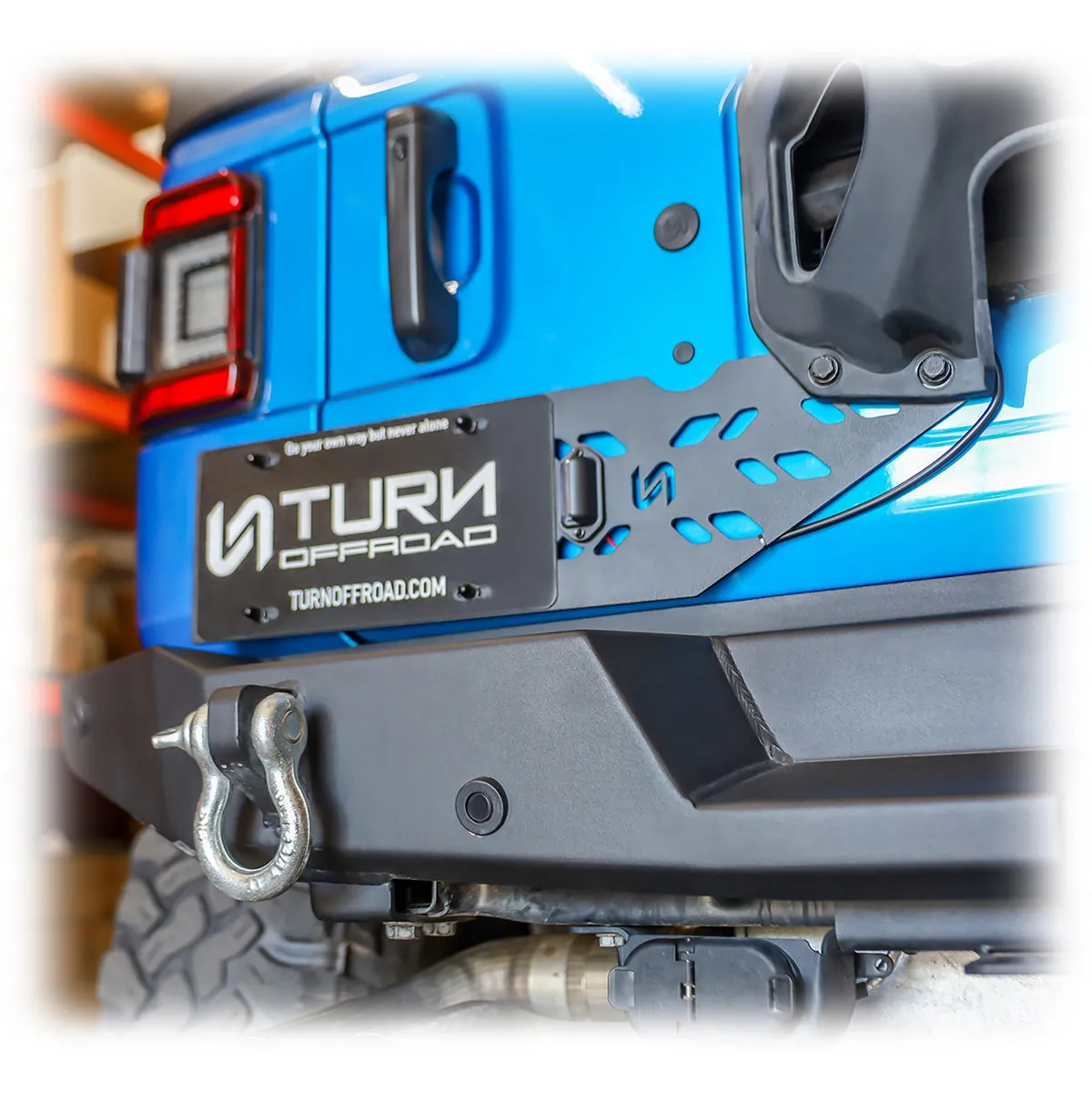 Turn Offroad black license plate relocation bracket mounted on Jeep Wrangler JL tire carrier with oversized spare tire