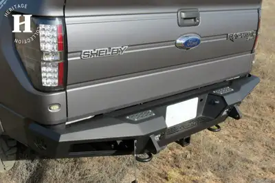 Addictive Desert Designs 2010 - 2014 Ford Raptor 2009 - 2014 Ford F-150 2011 - 2014 Ford Ecoboost F-150 HoneyBadger Rear Bumper with Integrated Storage Box and Backup Sensor cutouts with Dually mounts in Hammer Black with Satin Black panels.
